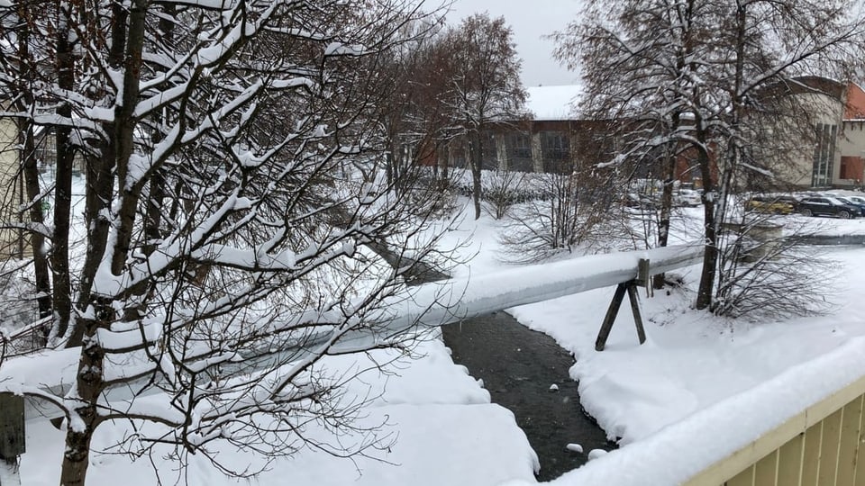 Ein kleiner Fluss  umgeben von Schnee. 