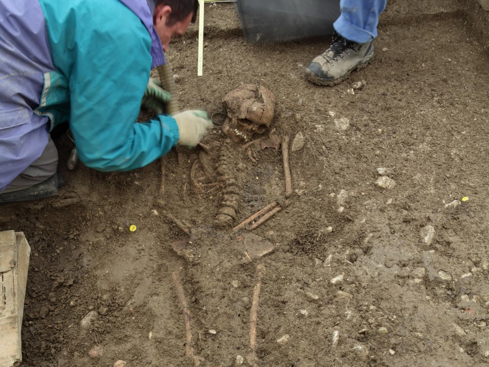 Skelett einer Frau, die mit grossen Ohrringen ins Grab gelegt wurde.