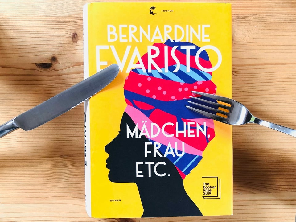 «Mädchen, Frau etc.» von Bernardine Evaristo liegt auf einem Kiefernbrett