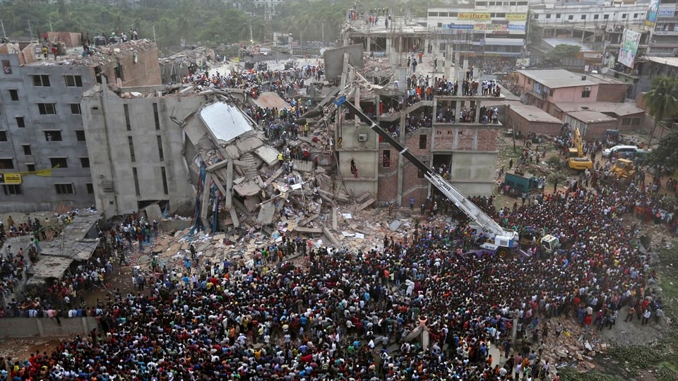 Menschenmasse vor dem eingestürzten Gebäude.