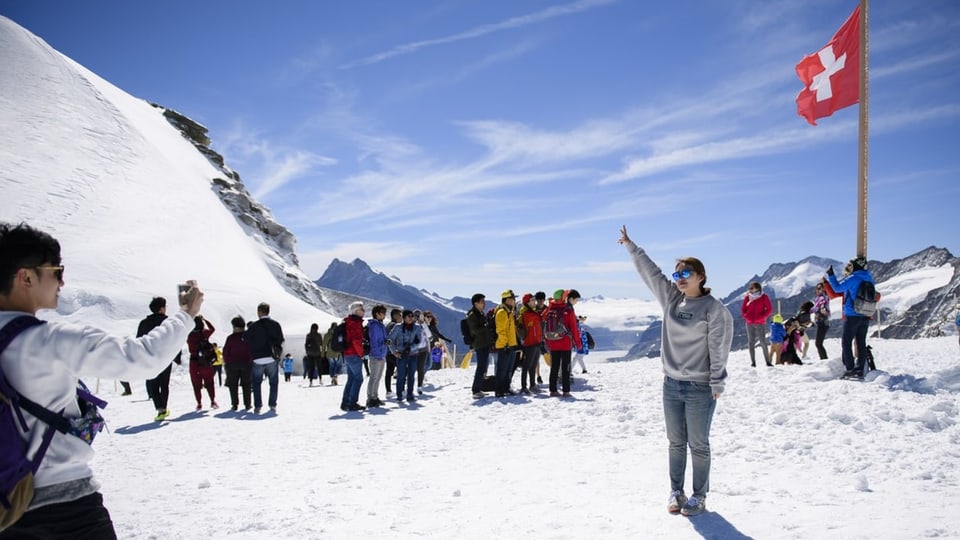 Eine grosse Gruppe Tourist:innen auf dem Jungfraujoch