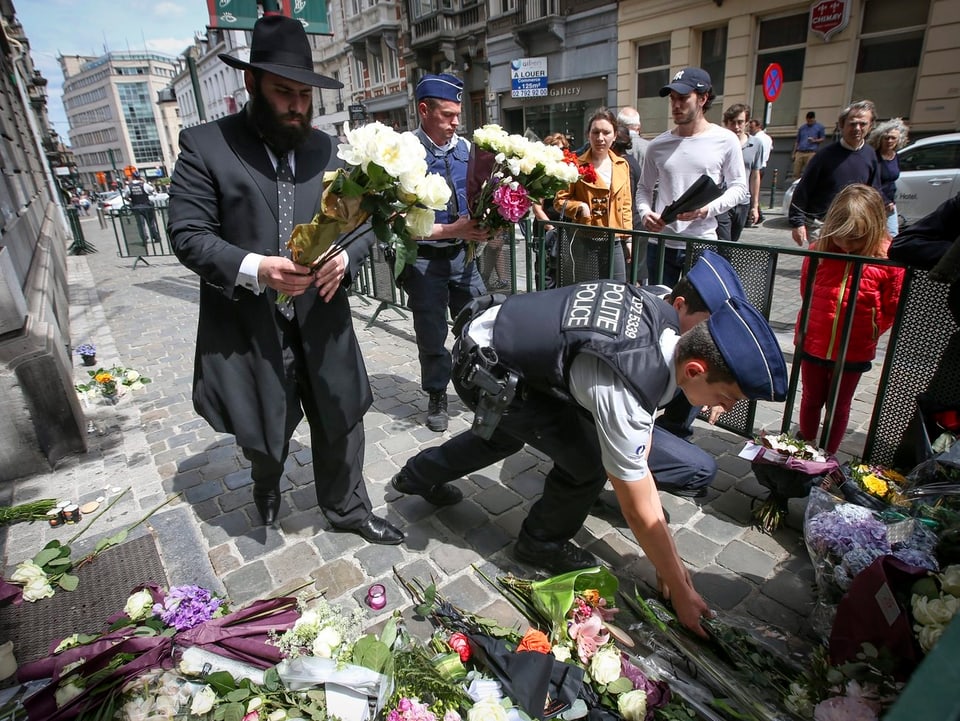 Polizisten und Privatpersonen legen Blumen nieder