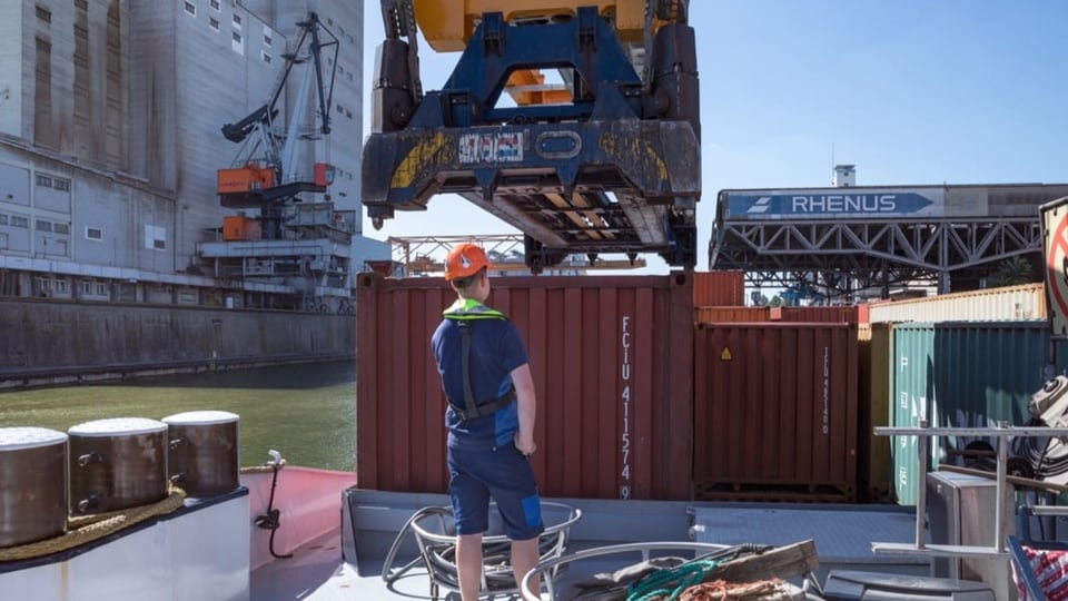 Mann mit Kran auf Schiff