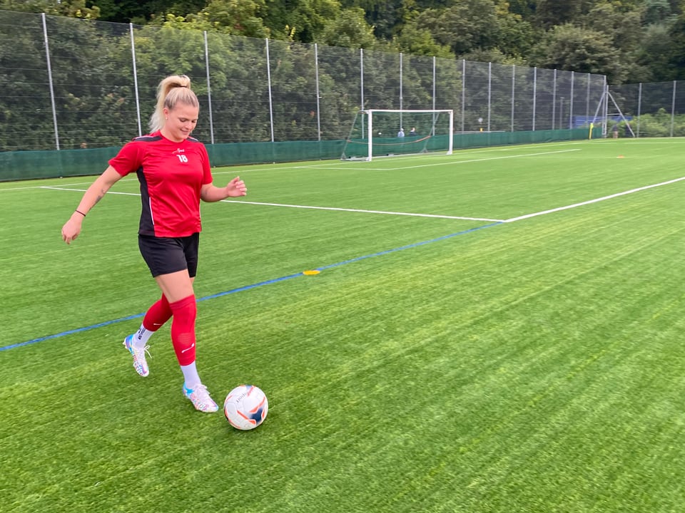 Spielerin Brandy zeigt den Kinderreportern Fussballtricks auf dem Feld. 