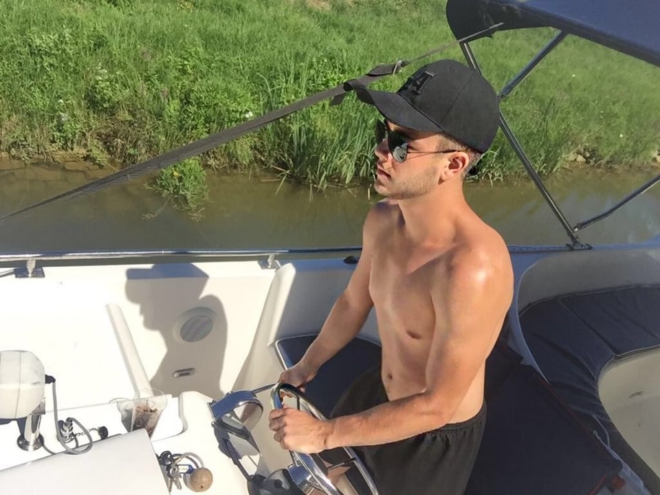 Luca Hänni mit nacktem Oberkörper am Steuer des Bootes. 