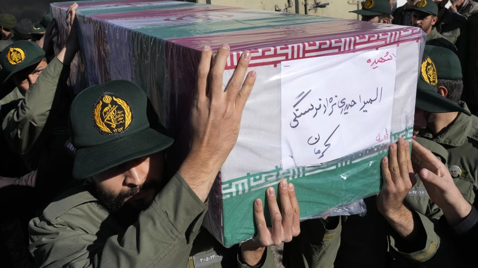 Iranian Revolutionary Guards carry the coffin of one of the victims of the Kerman bombing.