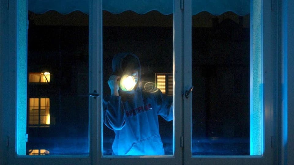 Mann leuchtet in der Nacht mit Taschenlampe in Haus.
