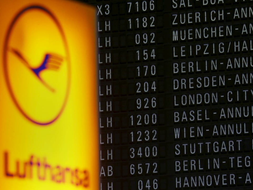 Das Lufthansa Logo vor einer Abflugtafel