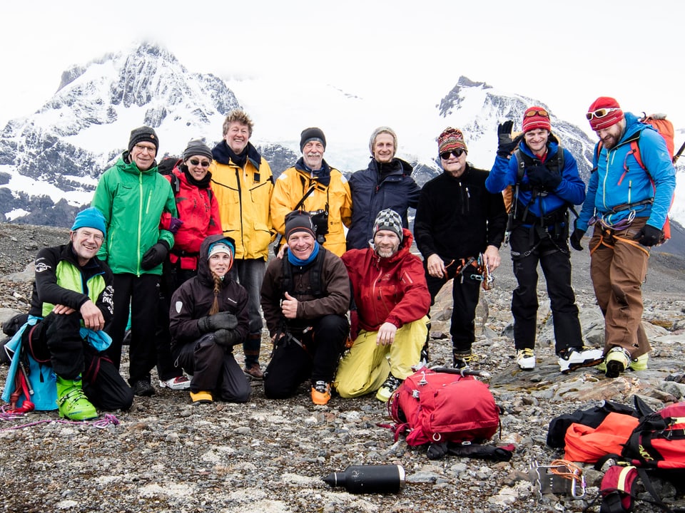 Die Gruppe posiert vor verschneiten Bergn.
