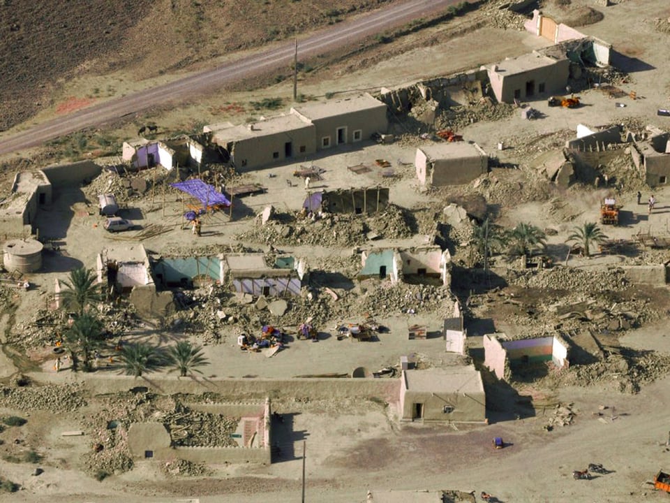 Ein kleines Dorf in Pakistan mit zerstörten Lehmhütten. Es ist eine Luftbildaufnahme. 