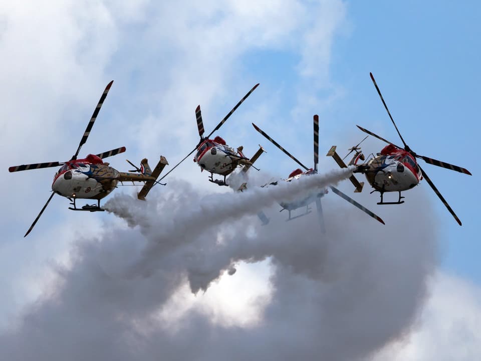 Vier Helikopter bei einem Kunststück.