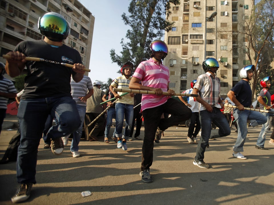 Mursi-Anhänger in kairo üben den Widerstand: Sie tragen Helme und halten Schlagstöcke in ihren Händen. (reuters)
