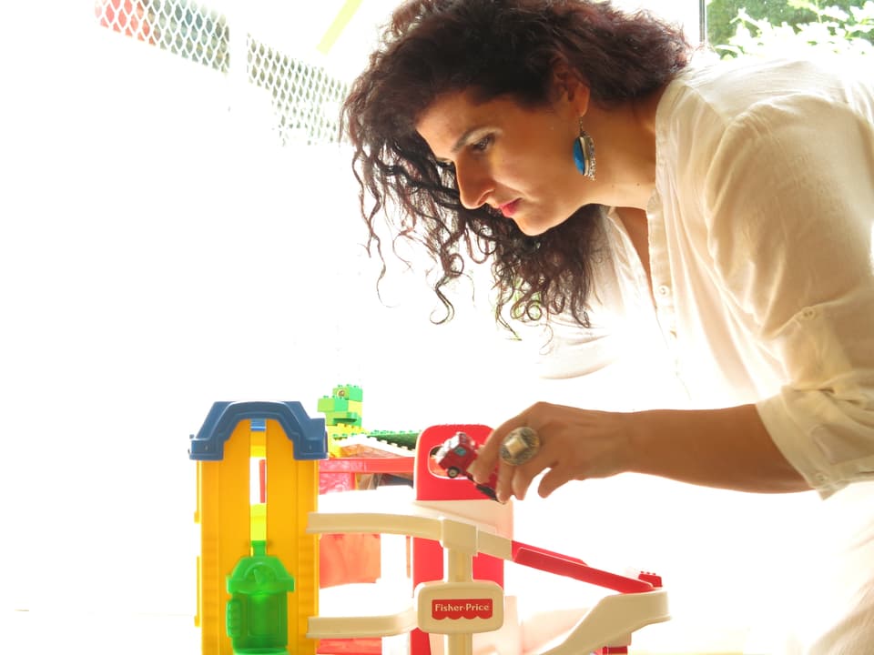 Suela Kasmi macht sich mit einem Spielzeugauto zu schaffen. 