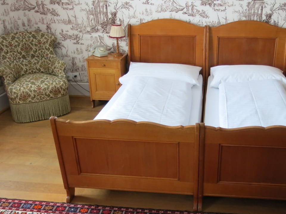 Ein altes holziges Doppelbett in einem der Zimmer des Hotels.