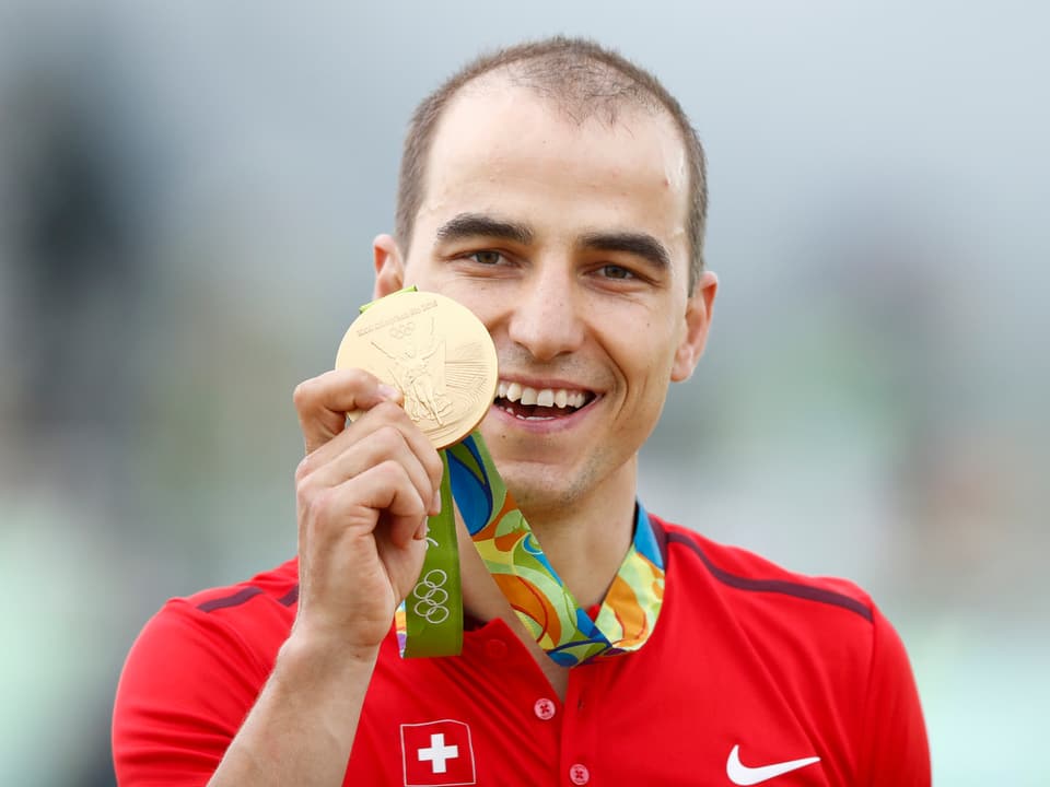 Nino Schurter posiert mit der Olympia-Goldmedaille.