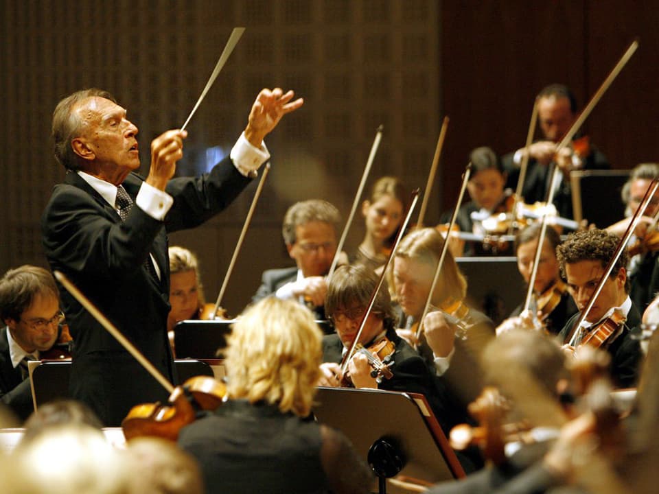 Ein Mann dirigiert ein Orchester.