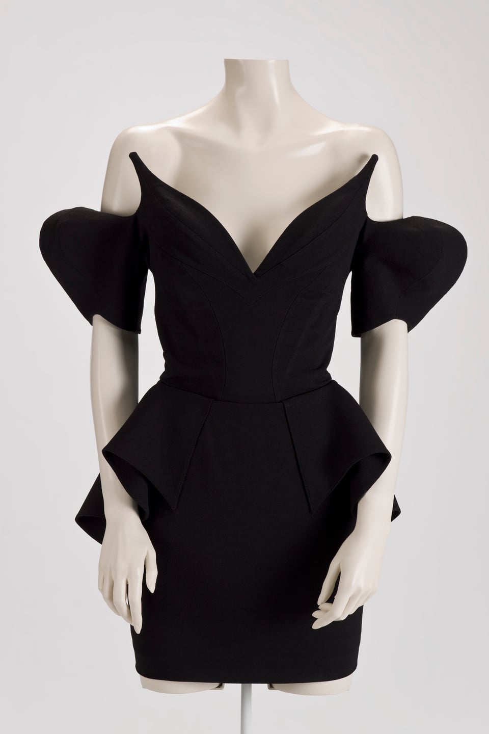 Ein schwarzes Kleid mit extravaganten Ärmeln ist an einer Schaufenster-Puppe ausgestellt.