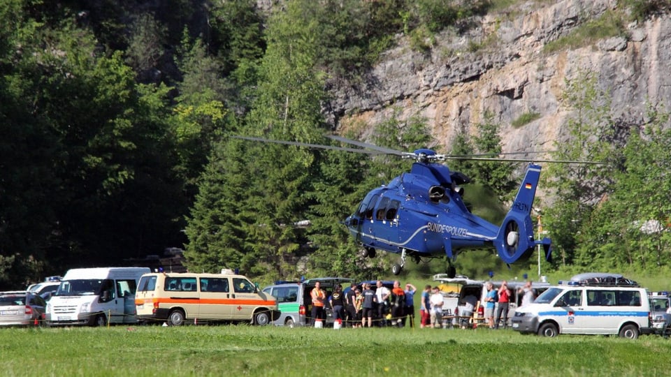 Rettungshelikopter bei der Landung vor Sanitätsautos.