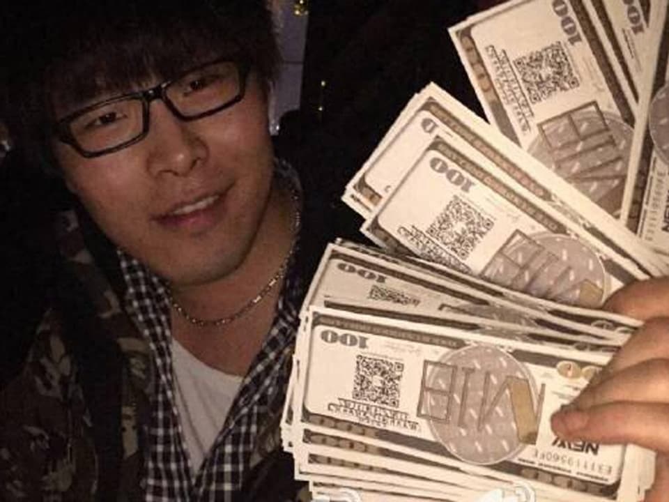 Ein junger Mann zeigt die nachgemachten 100-US-Dollar-Scheine mit dem Aufdruck «Neujahr 2015» und den Namen des Nachtklubs.