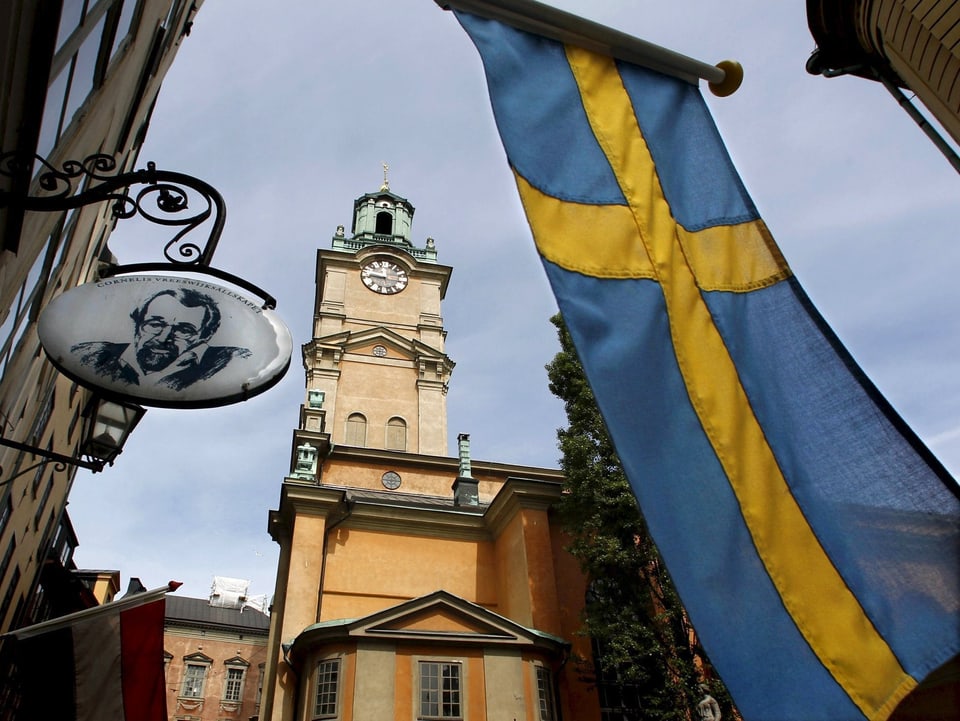Blick auf eine Kirche mit einer Schweden-Flagge im Vordergrund.
