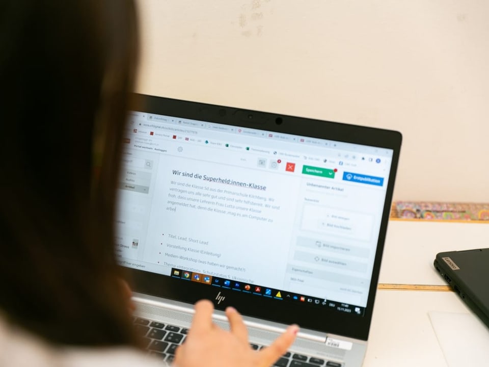 Ein Mädchen schreibt am Computer einen Teil des Artikels.