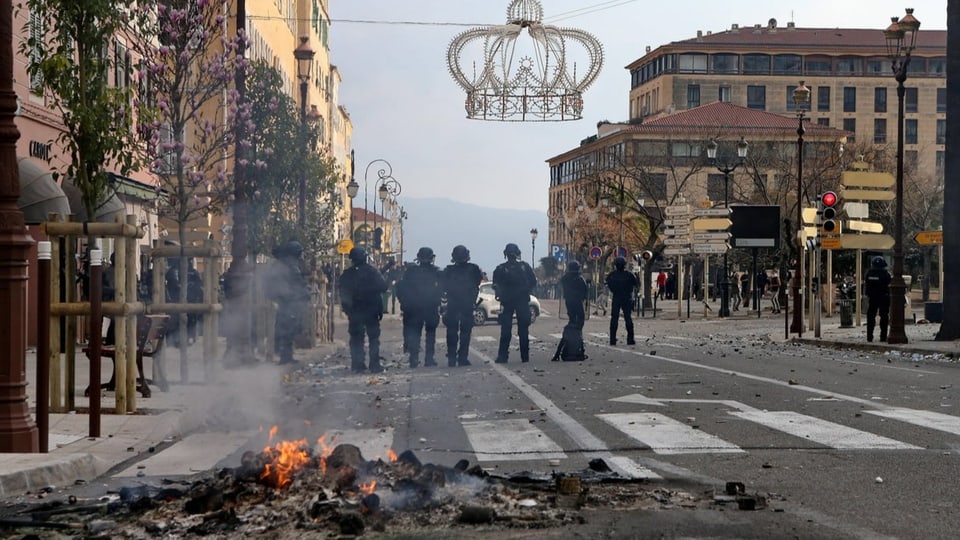 Polizisten und ein kleines Feuer auf einer Strasse in Ajaccio.
