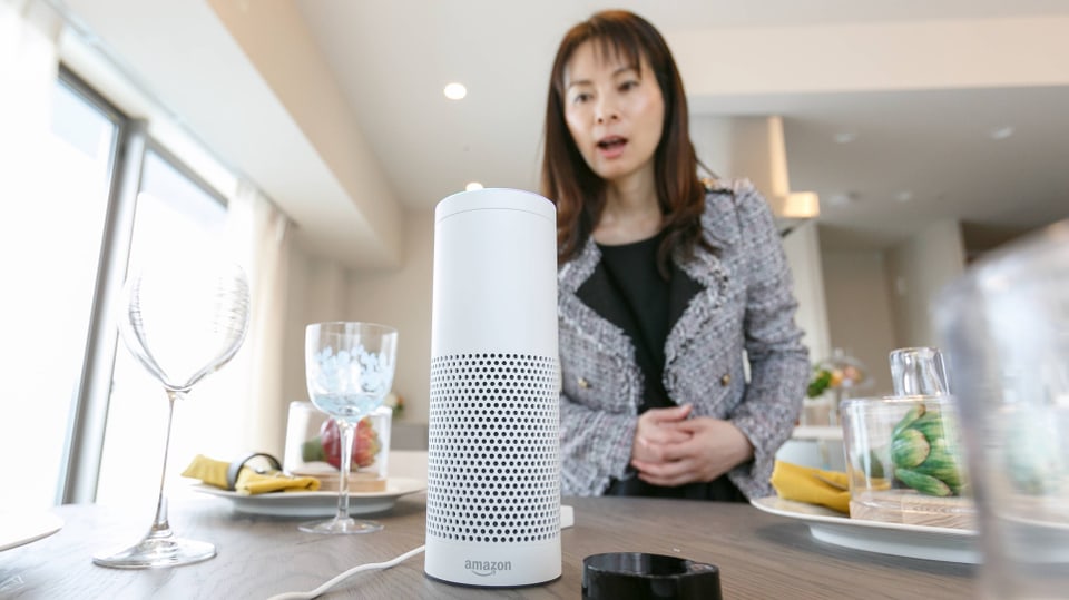 Symbolbild: Eine Frau spricht zum Amazon-Alexa-Lautsprecher/Mikrofon.