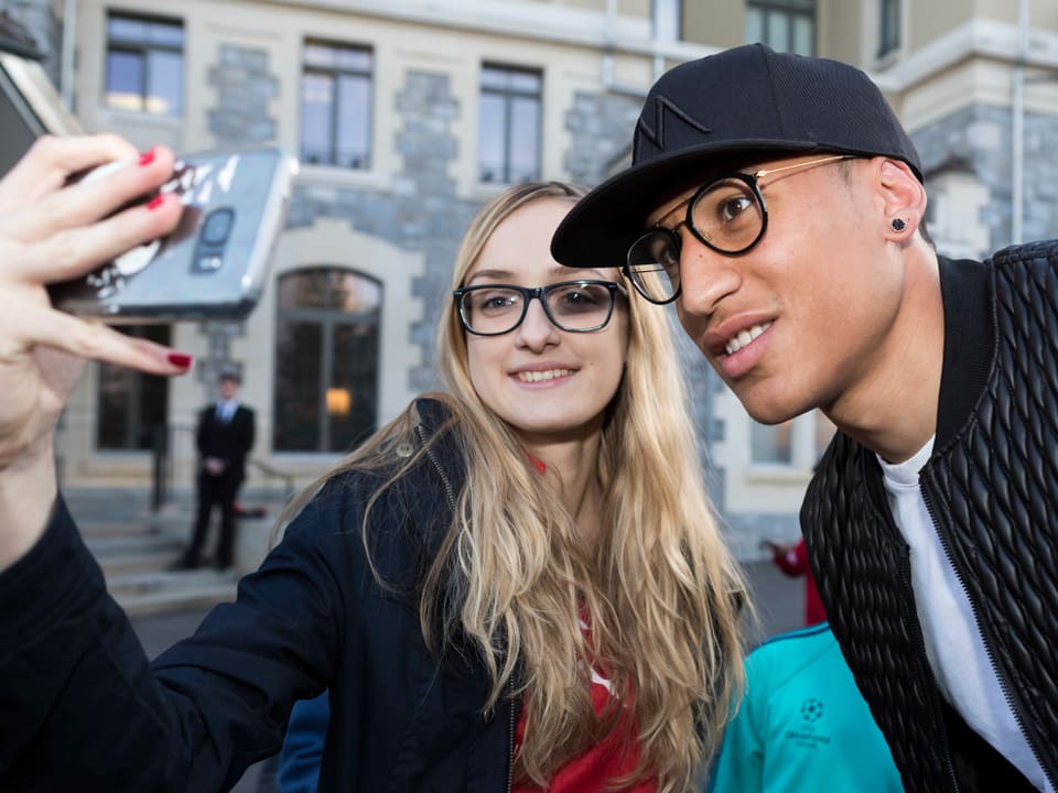 Leo Lacroix macht mit einem blonden Fan ein Selfie.