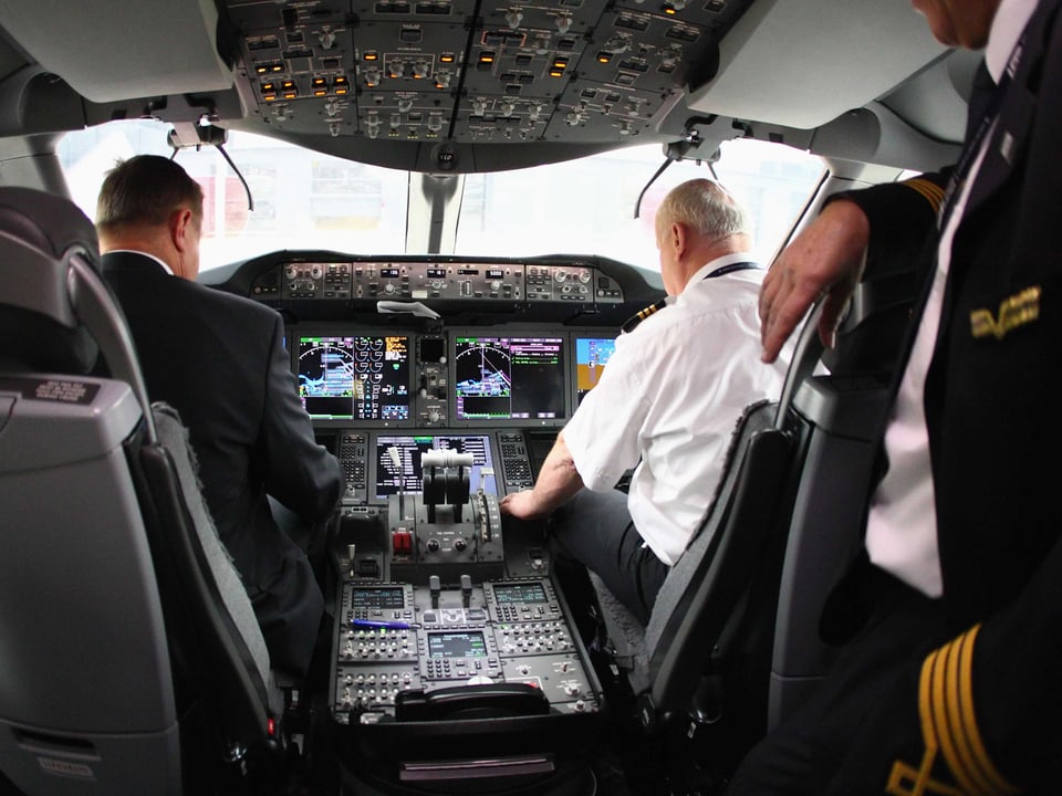 Blick in ein 787-Cockpit. Zwei Piloten bedienen die Instrumente.