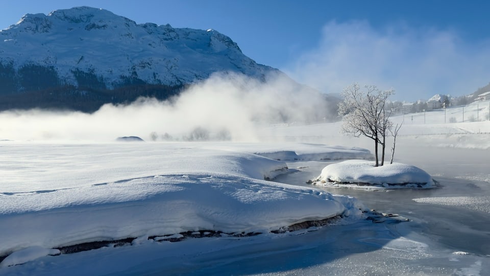 Wolkenlose Schneelandschaft in Samedan mit rauchenden Gewässern.