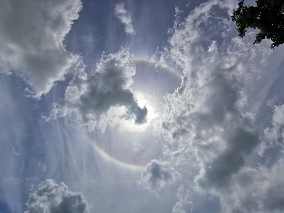 Regenbogen-Ring um die Sonne am milchigen Himmel