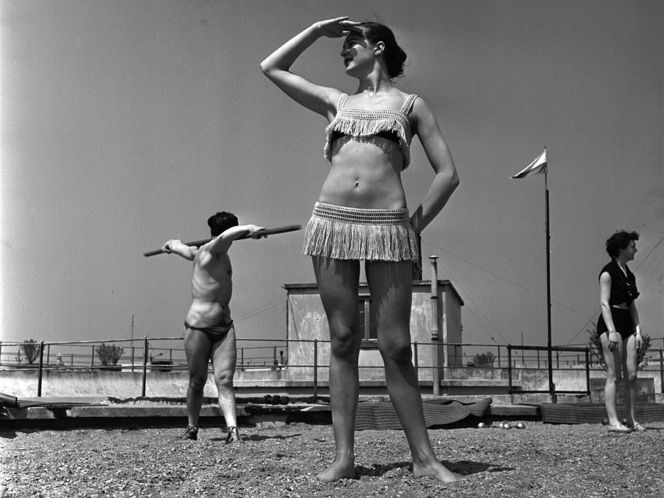 Frau in einem Bikini mit Fransen am Strand stehend, Ausschau haltend.