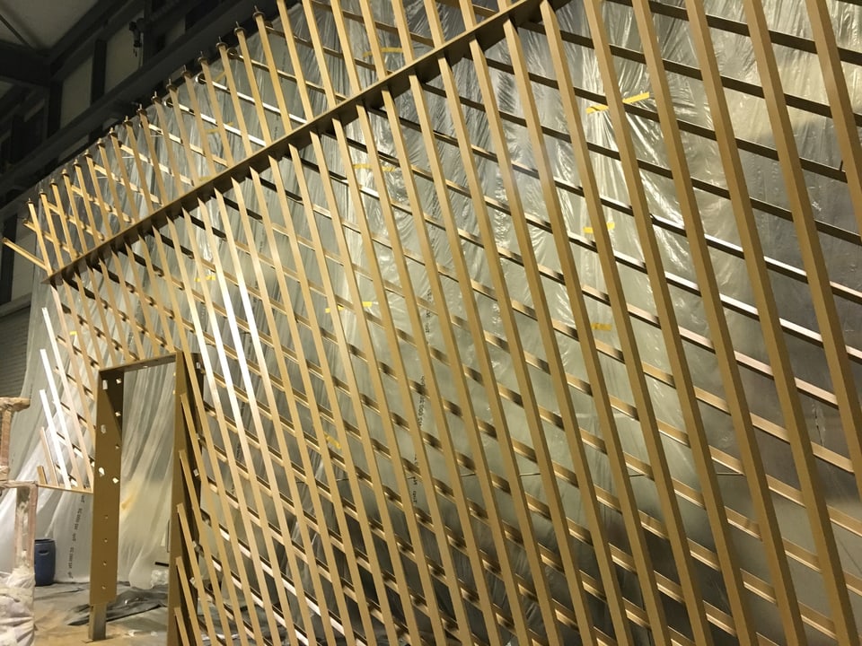 Eine goldene Wand aus Stahlstäben.