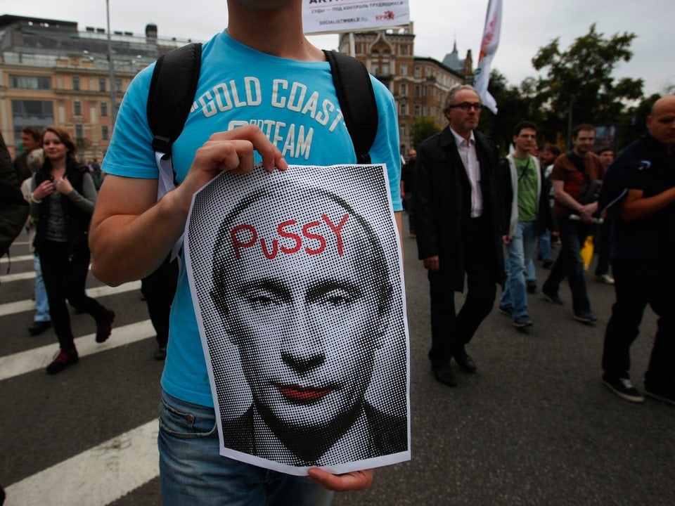 Protestierender mit einem Plakat mit Putins Konterfei. Darauf ist das Wort «Pussy» geschrieben. Eine Anspielung auf die feministische Protestgruppe «Pussy Riot».