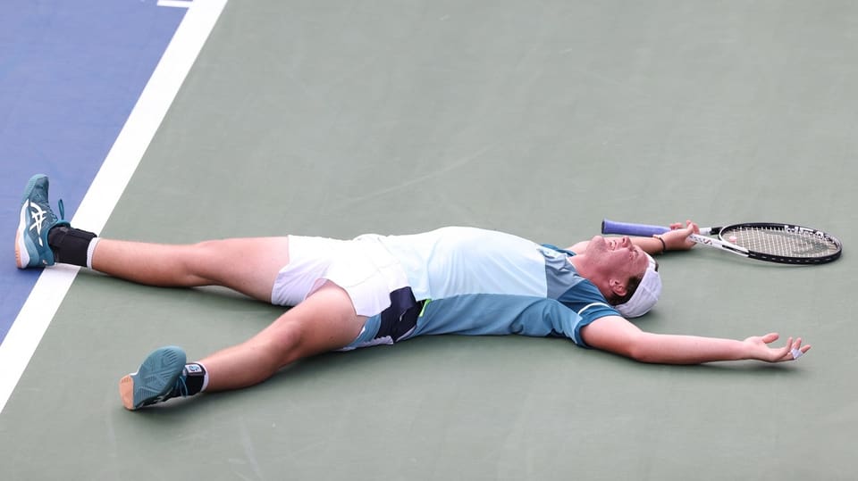 Tennisspieler liegt erschöpft am Boden.