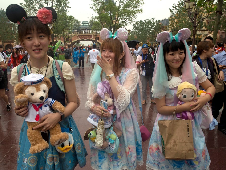 Chinesische Besucherinnen mit Mickey-Mouse-Hüten im Disneyland Shanghai