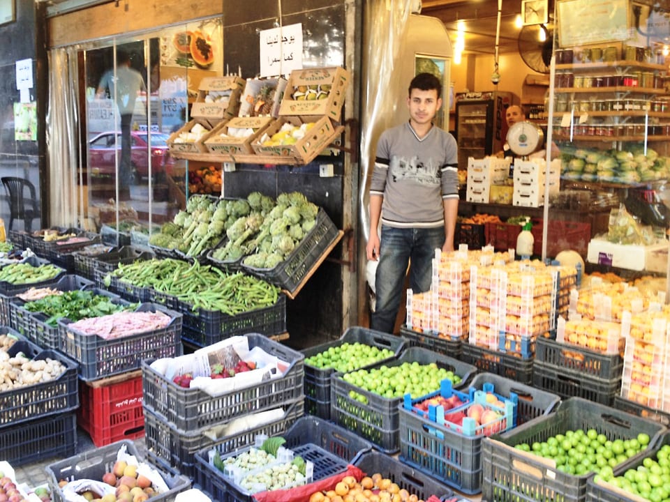 Strassenhändler in Beirut zwischen Gemüsekisten.