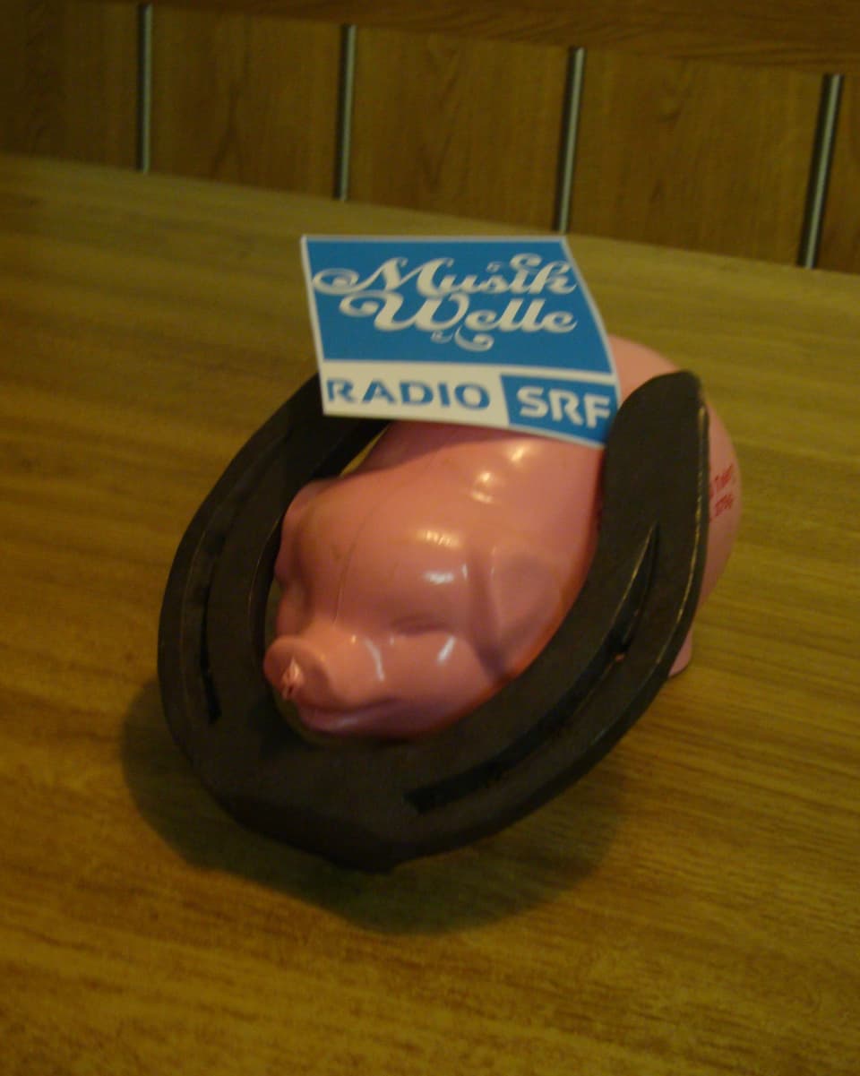 Rosarotes Plastiksäuli mit Hufeisen und dem Logo von Radio SRF Musikwelle.