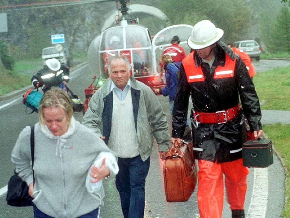 Personen mit Koffern evakuiert