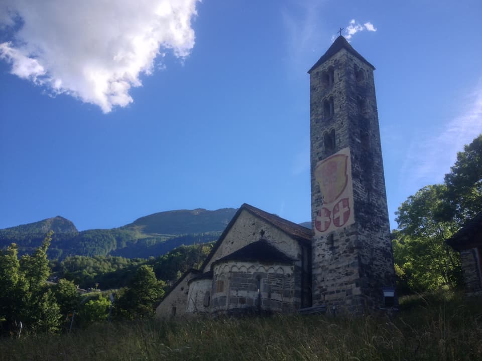 Foto der Kirche mit Zeichnungen der Urner Wappen am Kirchturm