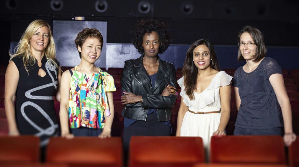 Vier Frauen stehen nebeneinander in einem Kinosaal.