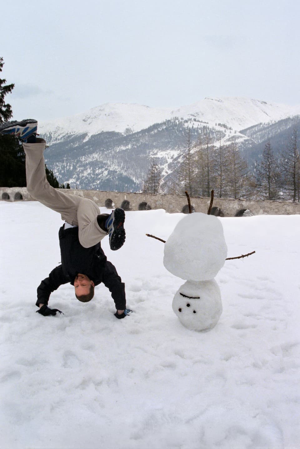 Der britische Künstler David Shrigley neben seinem Werk Upside down Snowman, am «Young Art Weekend 2000» vor dem Alpenschloss-Hotel Castell in Zuoz, Kanton Graubünden, 7. April 2000.