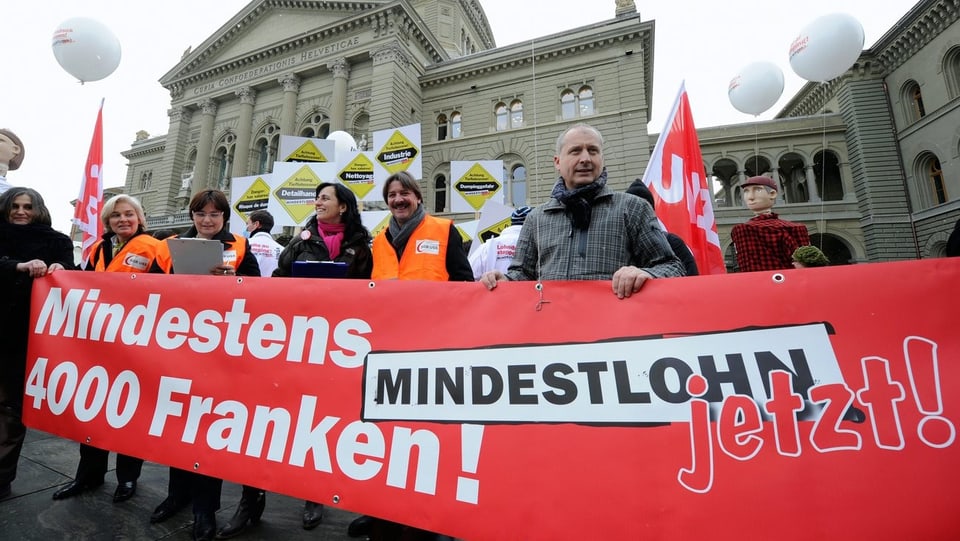 Demonstranten mit Banner vor dem Bundesplatz.