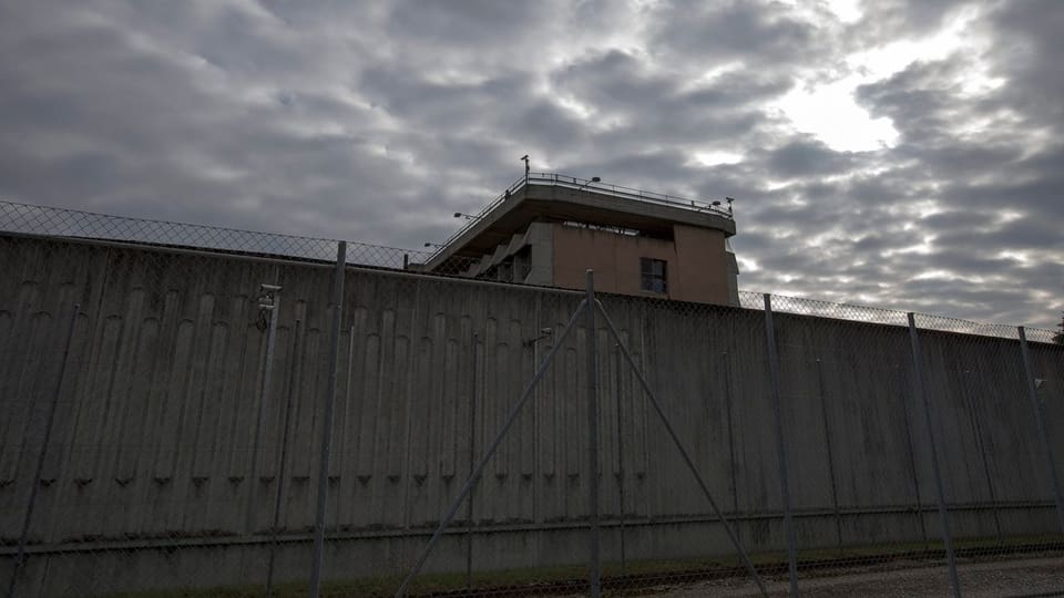 Eine Aufnahme einer hohen, grauen Mauer eines Gefängnisses.
