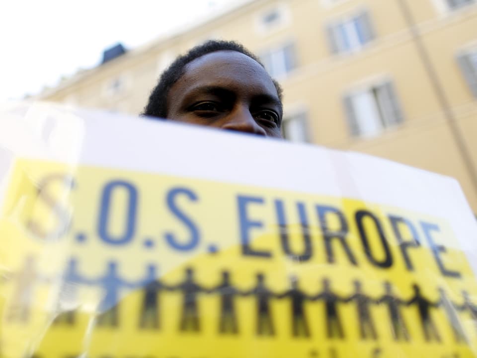Ein Flüchtling hält ein Schild mit «SOS Europe» in den Händen.