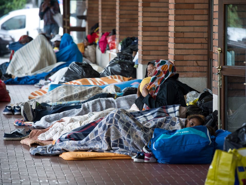Menschen in Schlafsäcken am Bahnhof Como