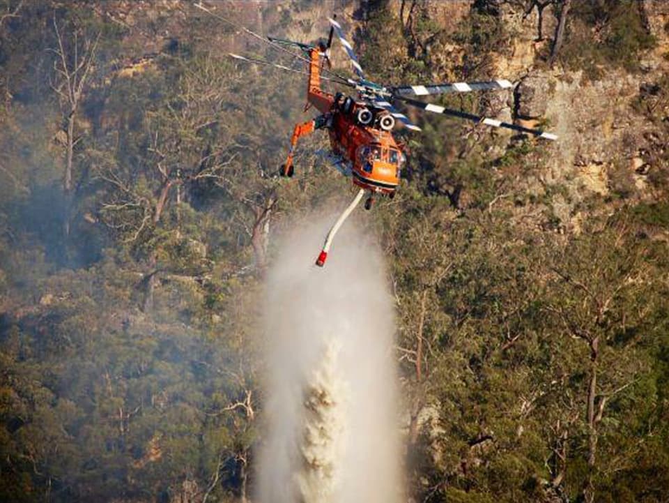 Hubschrauber der Feuerwehr lässt Löschwasser ab (keystone) 