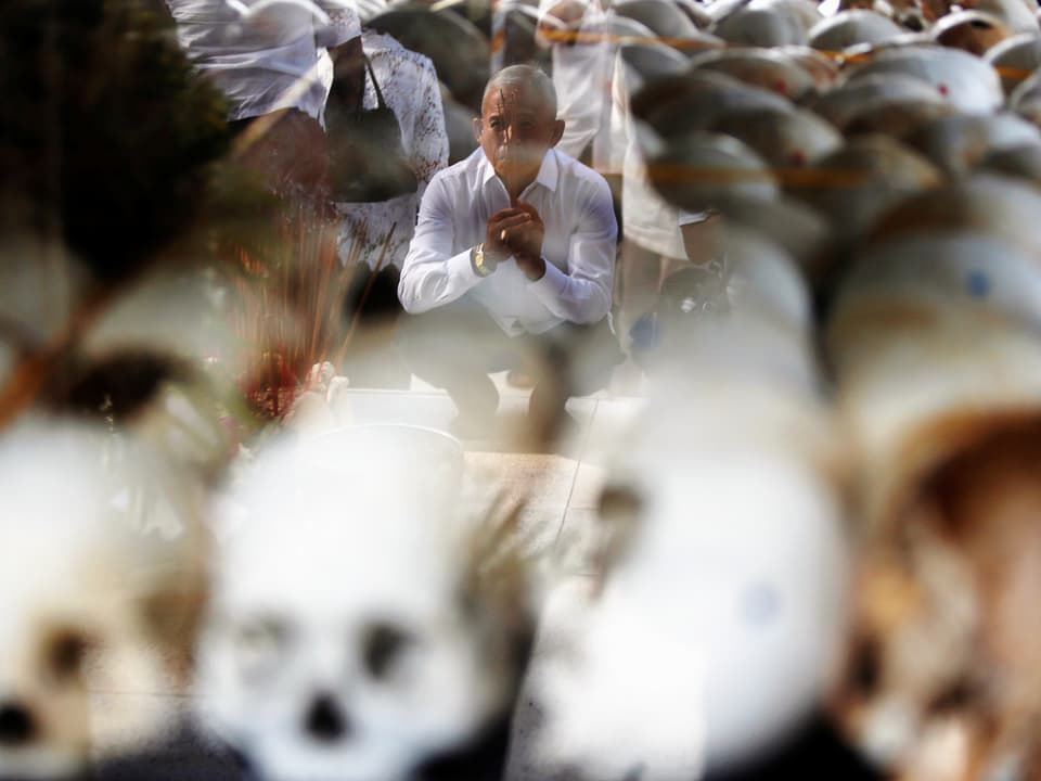 Trauernder sitzt hinter aufgereihten Schädeln, am «Tag des Zorns»