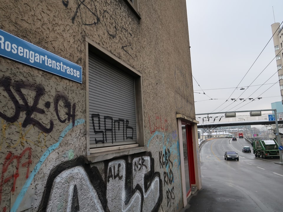 Strassenschild an Haus mit Graffiti