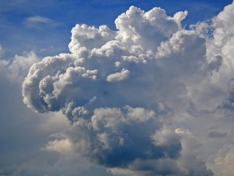 Bild mit viel Wolke und wenig blauem Himmel. Die riesige Gewitterwolke sieht aus wie ein Blumenkohl. 